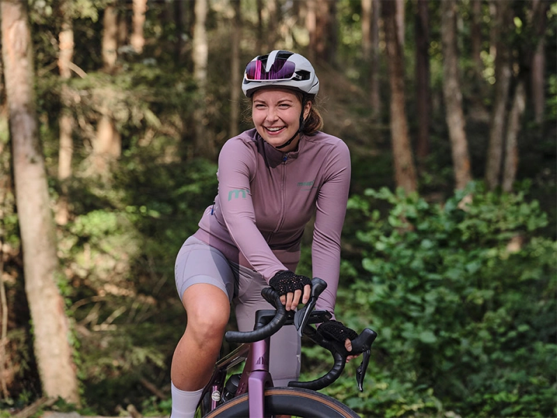 Rennradlerin im Wald lachend Rennradlerin im Wald lachend